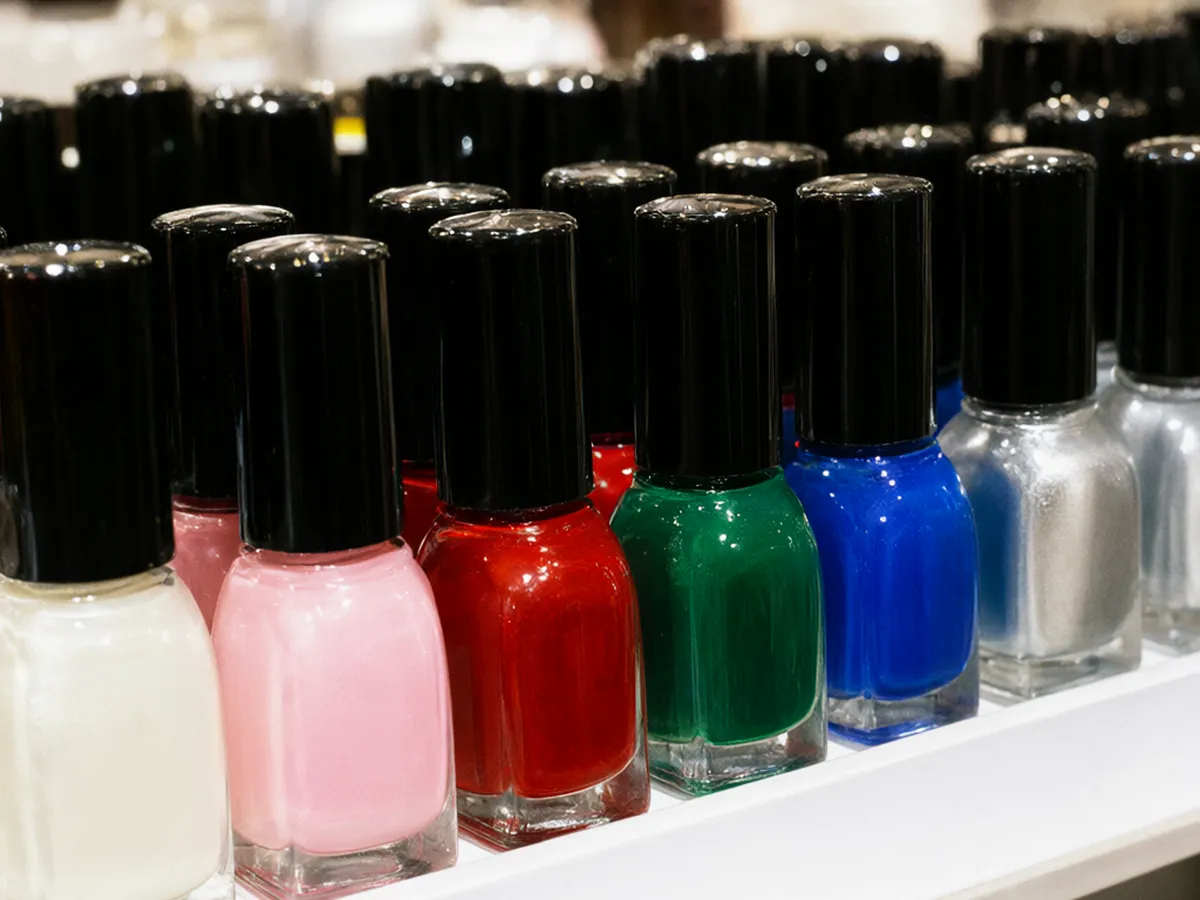 Rows of glossy nail polish bottles in pearl, pink, red, emerald, cobalt and silver
